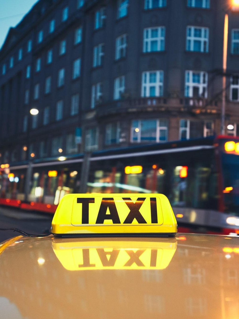 taxi-car-and-tram-of-public-transportation-on-the-city-street-at-night.jpg
